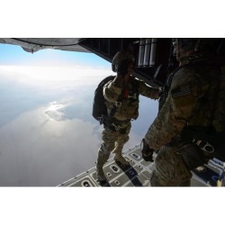 A pararescueman salutes an officer before jumping from a HC-130 Hercules Poster Print (34 x 22)