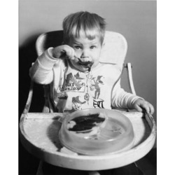 Posterazzi SAL2559717 Baby Sitting in a High Chair & Eating Baby Food Poster Print - 18 x 24 in.